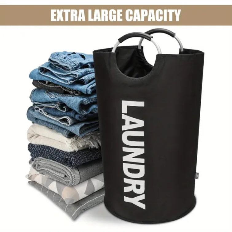 Black laundry basket with 'LAUNDRY' text next to folded clothes on a white background