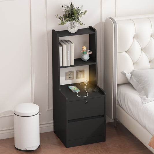 Black nightstand with drawer, books, and a plant next to a bed in a bedroom.