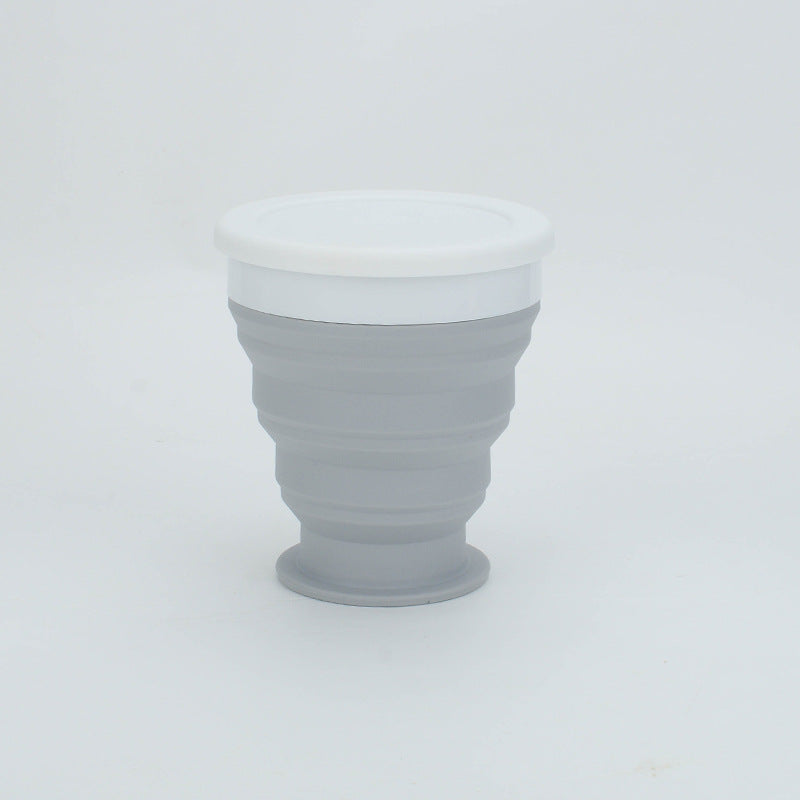 Collapsible gray cup with white lid on a light gray background