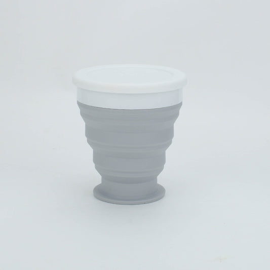 Collapsible gray cup with white lid on a light gray background