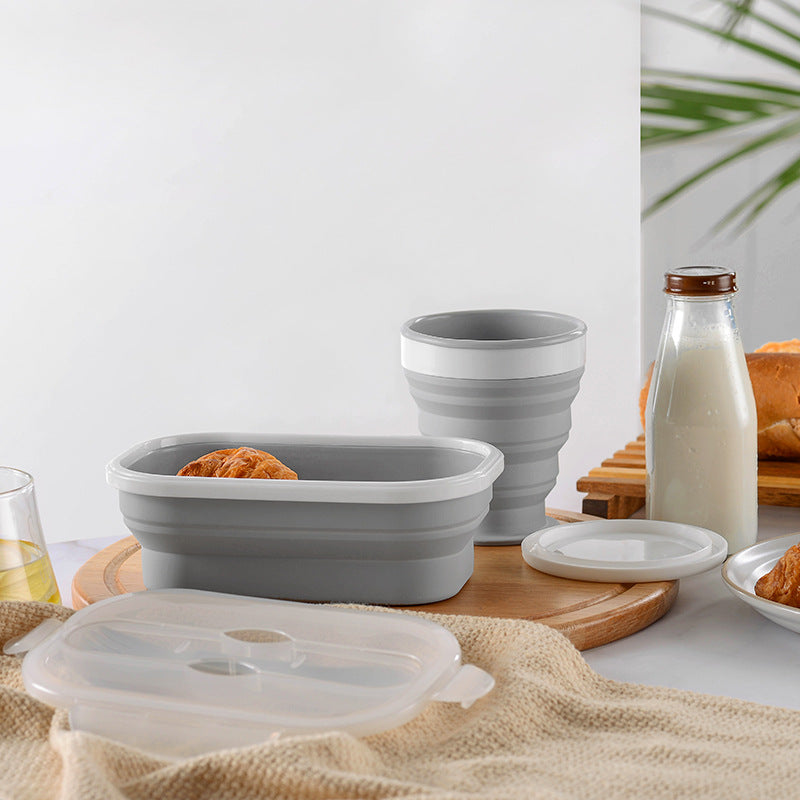 Collapsible silicone bowls and containers on a table with a glass of milk and bread.