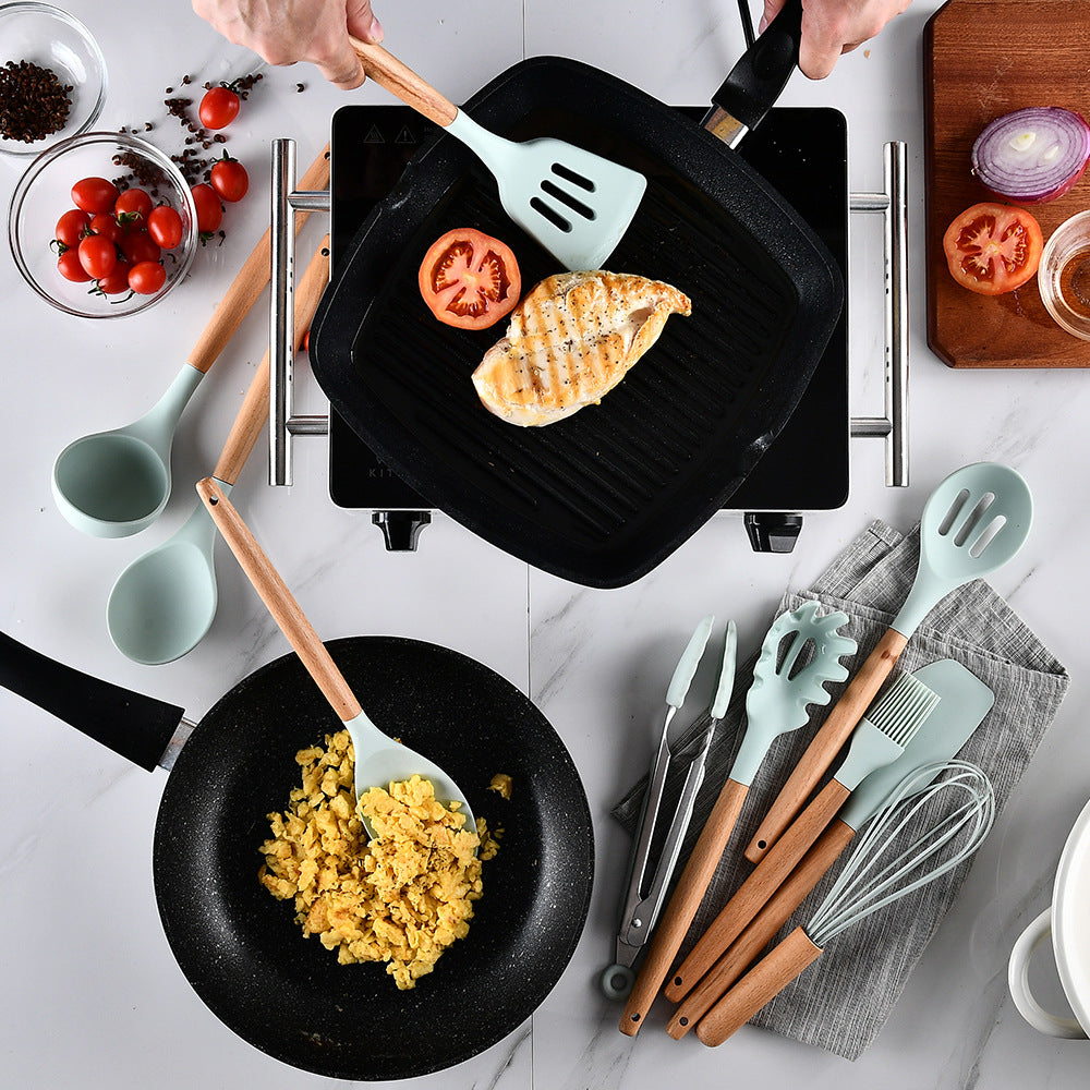 Cooking scene with a griddle, frying pan, and various utensils on a marble surface.