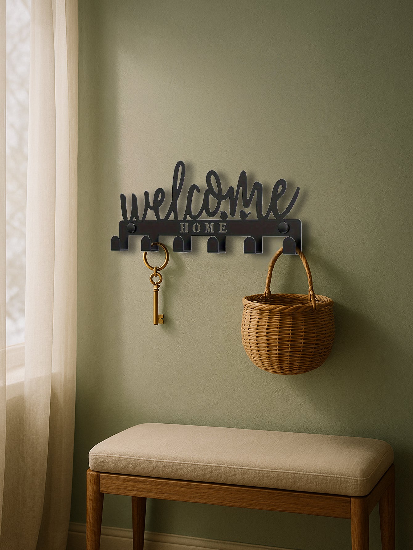 Decorative 'welcome home' sign with hooks on a green wall above a bench.