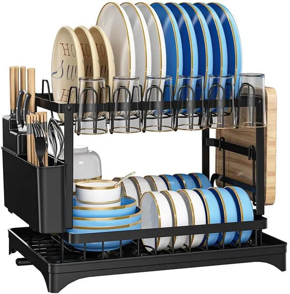 Dish drying rack with blue and white dishes, glasses, and cutlery on a white background