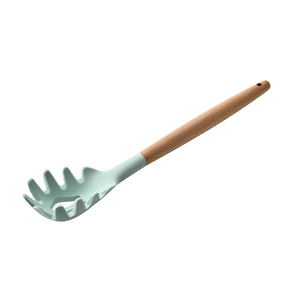 Light blue pasta server with wooden handle on a white background