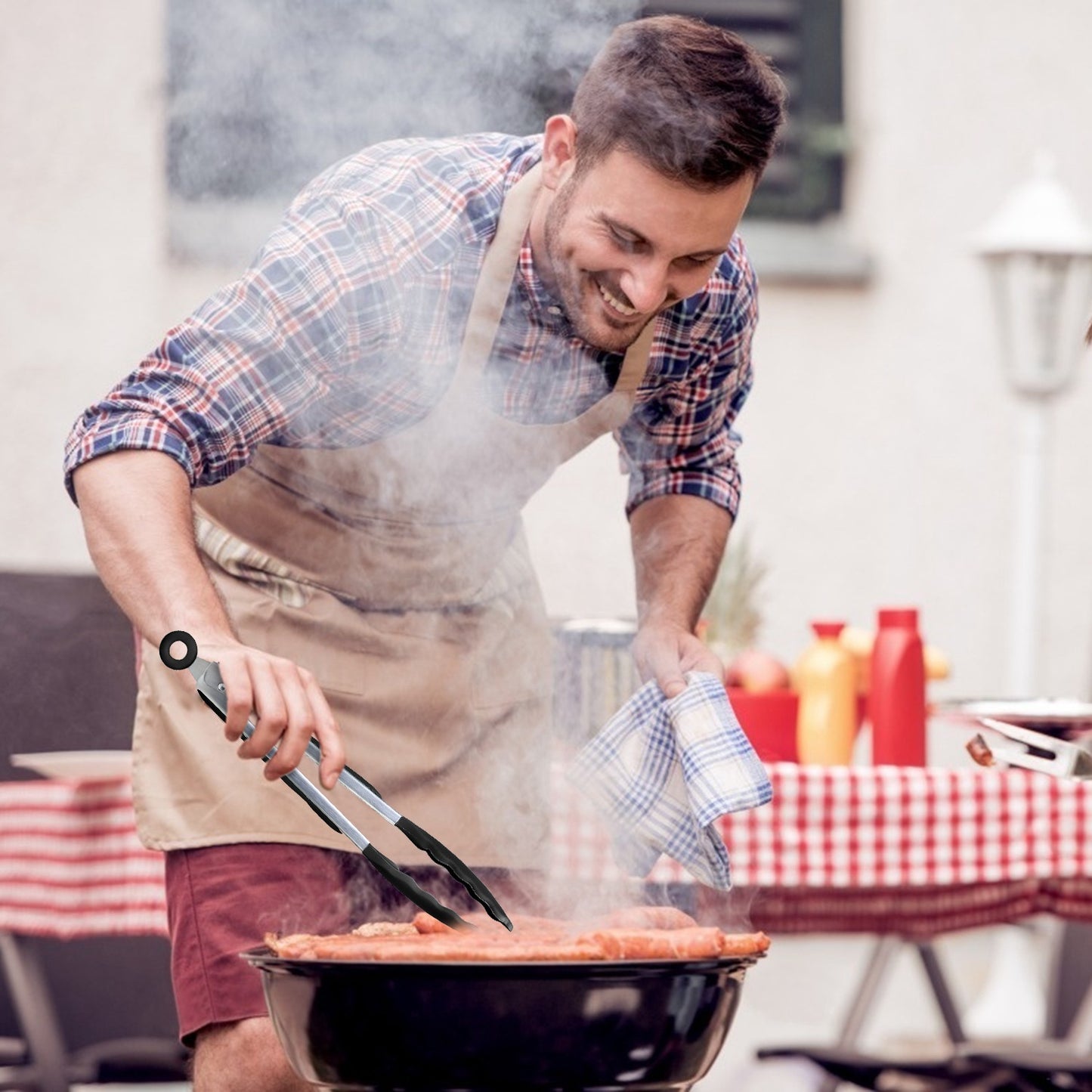 Man grilling food outdoors with a checkered tablecloth in the background
