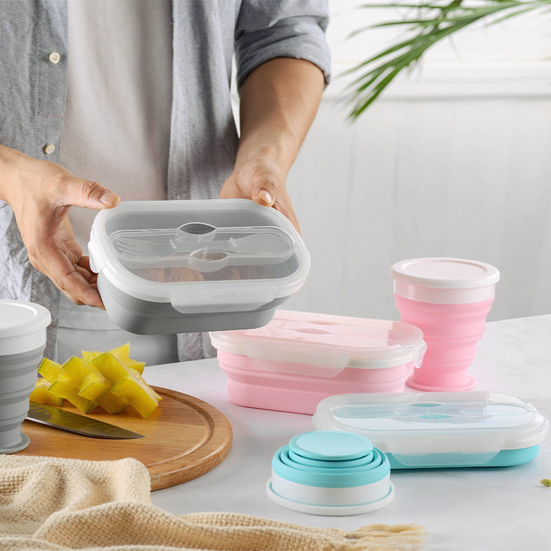Person holding a silicone food container with other silicone products on a table.