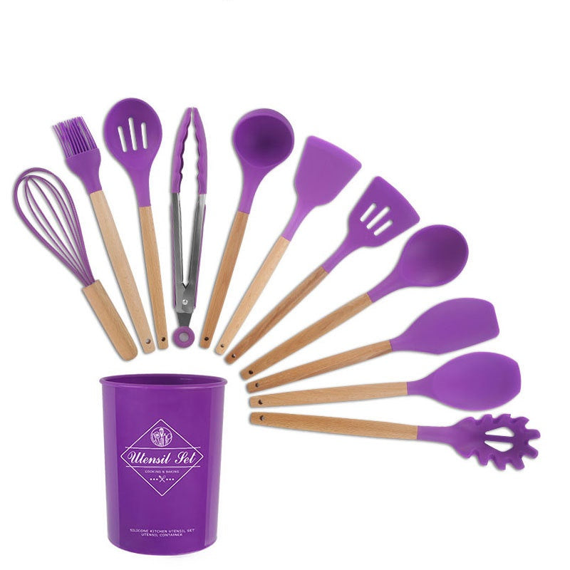 Purple kitchen utensil set with wooden handles in a purple container on a white background