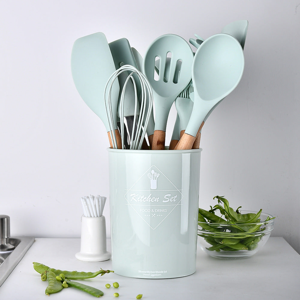 Set of kitchen utensils in a light blue holder on a kitchen counter.