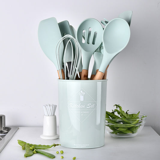 Set of kitchen utensils in a light blue holder on a kitchen counter.