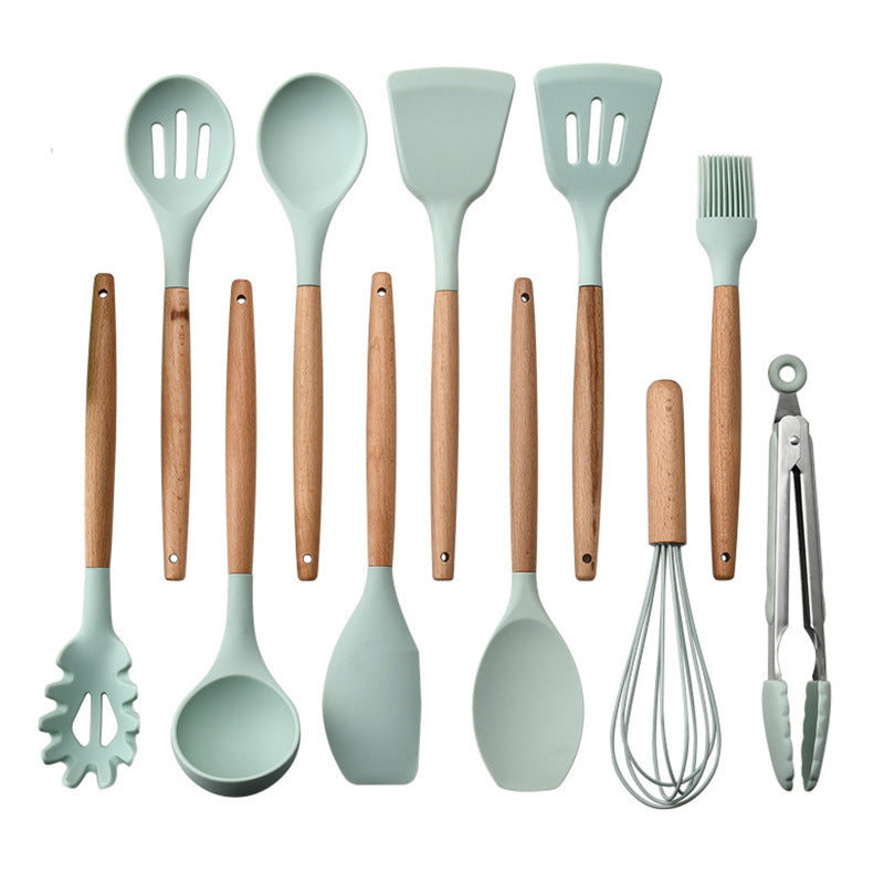 Set of kitchen utensils with green silicone heads and wooden handles on a white background