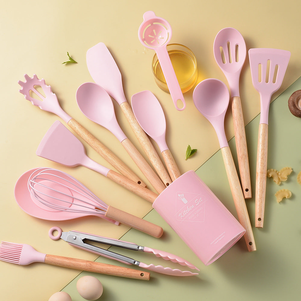 Set of pink and beige kitchen utensils on a yellow and green background