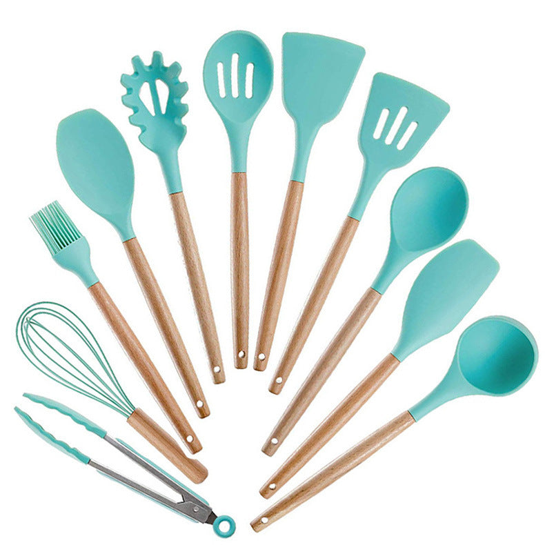 Set of turquoise silicone kitchen utensils with wooden handles on a white background
