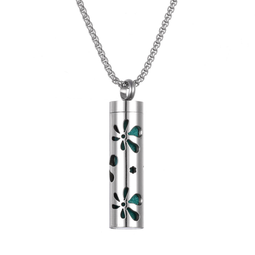 Silver cylindrical pendant with floral designs on a white background