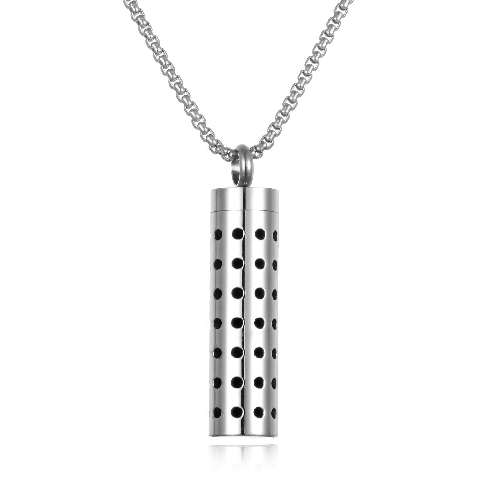 Silver cylindrical pendant with perforations on a white background
