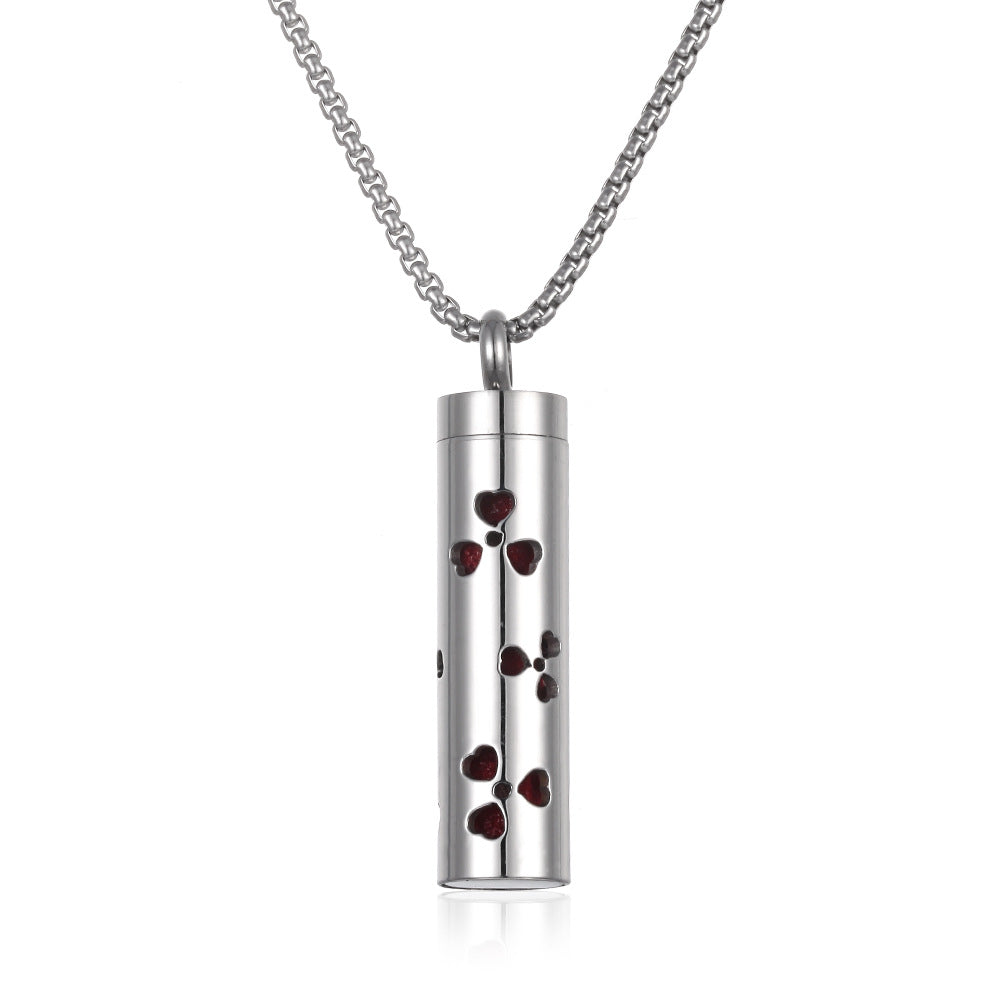 Silver cylindrical pendant with red heart shapes on a white background