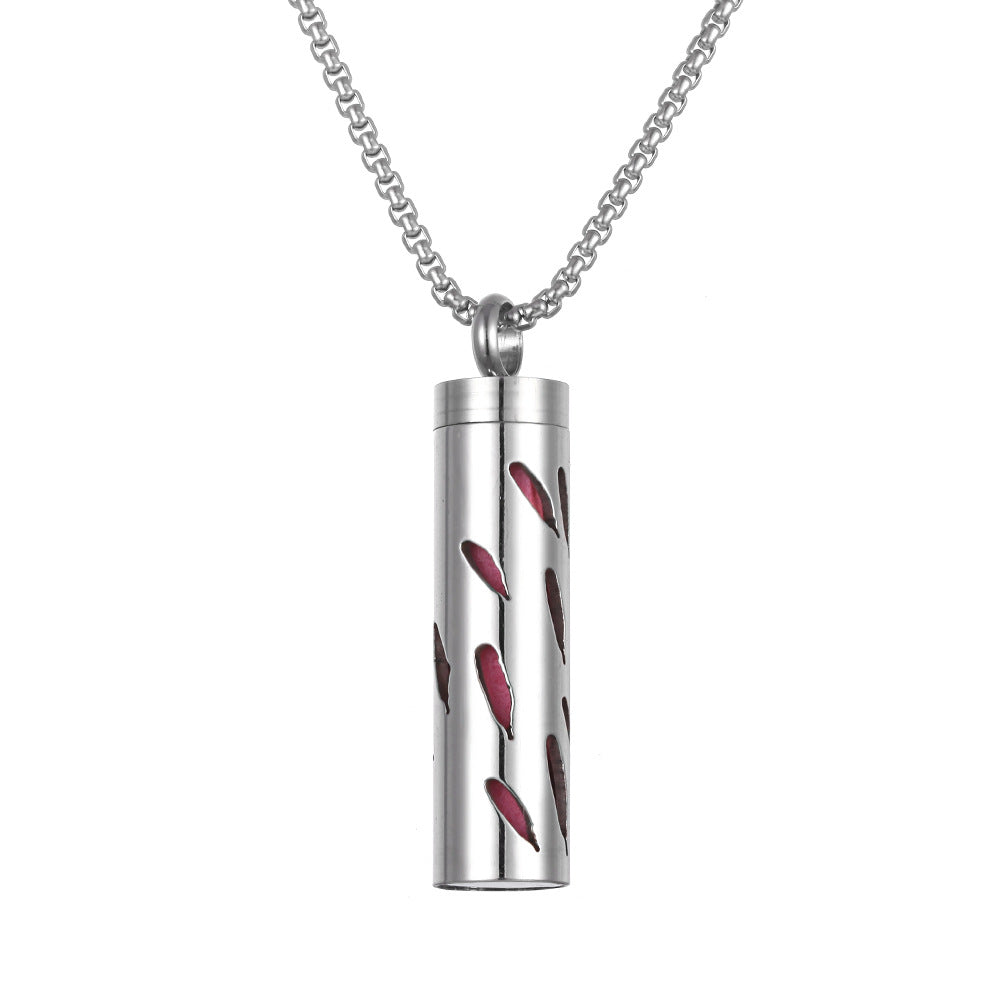 Silver cylindrical pendant with red leaf designs on a white background