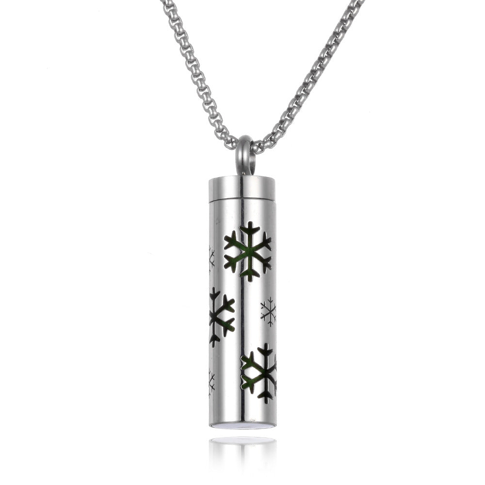 Silver cylindrical pendant with snowflake designs on a white background