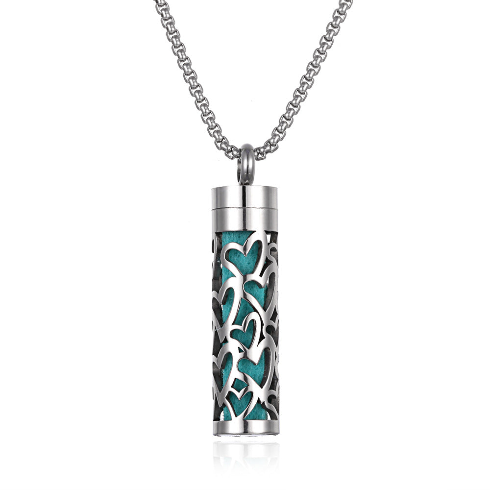 Silver cylindrical pendant with teal heart patterns on a white background